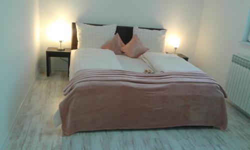 a bedroom with a large bed with two lamps on the side at Apartment VILLA MERCI in Sarajevo