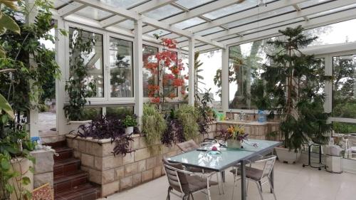 a greenhouse with a table and some plants at Sun Rose Apartments Sveti Stefan in Sveti Stefan
