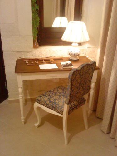 a desk with a lamp and a chair in a room at Kritamos Villa & Apartments in Kamilari