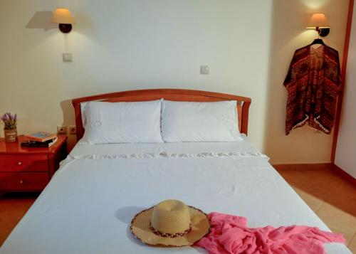 a bed with a hat on top of it at Kiotari Dreams in Kiotari