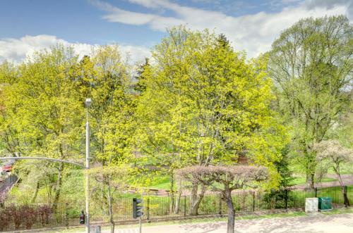 a fence in front of a park with trees at Ratusz B&B in Gdańsk