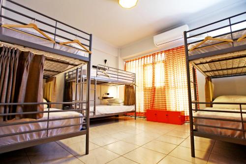 a room with three bunk beds in a room at Navel Orange Hostel in Taitung City