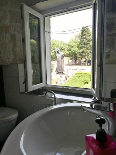 a bathroom with a bath tub and a window at Palace Inn Rooms in Split