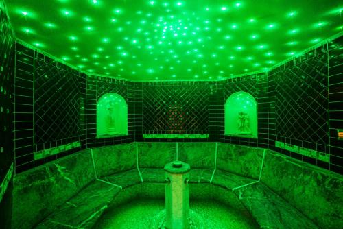 a green room with green lights on the wall at Cavallino Lovely Hotel in Andalo