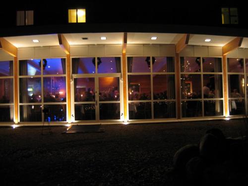 a building with a large glass window at night at Hotel Hehrne Kök & Konferens in Vänersborg