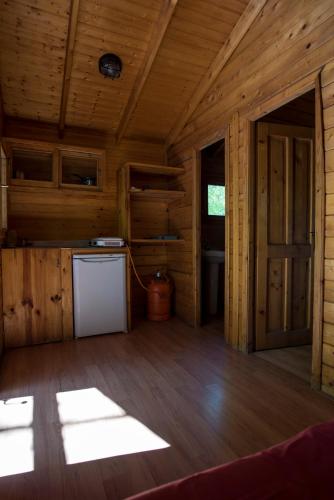 a room with a kitchen and a refrigerator in a cabin at Camping Noguera Pallaresa in Sort