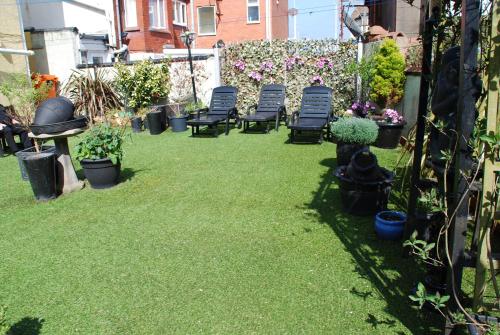 a yard with chairs and potted plants on the grass at Brincliffe Hotel in Blackpool