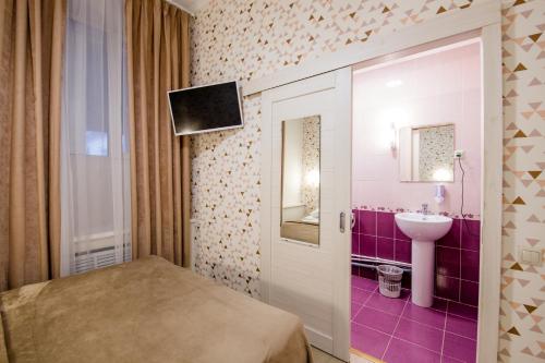 モスクワにあるVoyage Mini-hotelのベッドルーム(ベッド1台、シンク、テレビ付)