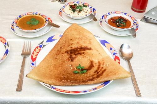 a table with a plate of soup and a piece of toast at Ramoji Film City- Tara Comfort Hotel in Pedda Ambarpet