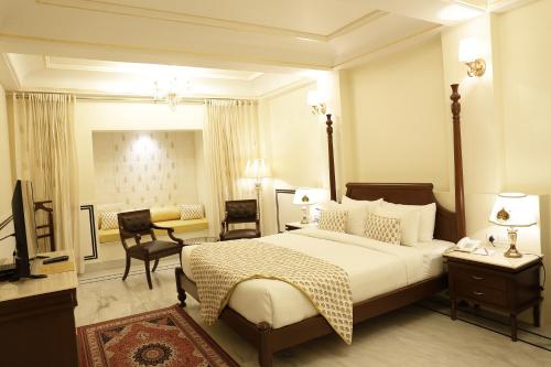 een hotelkamer met een bed en een woonkamer bij Laxmi Palace in Dausa