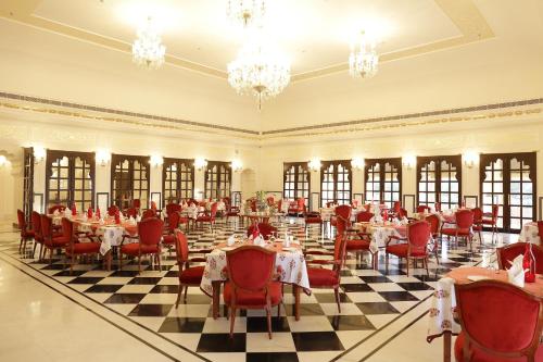 een feestzaal met tafels, stoelen en kroonluchters bij Laxmi Palace in Dausa