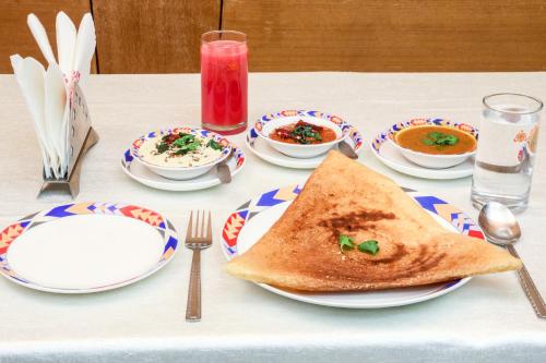 a table with plates of soup and a slice of toast at Ramoji Film City- Tara Comfort Hotel in Pedda Ambarpet