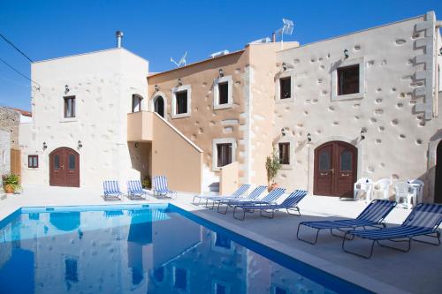 a group of chairs sitting next to a swimming pool at Villa Cardia in Kiriánna