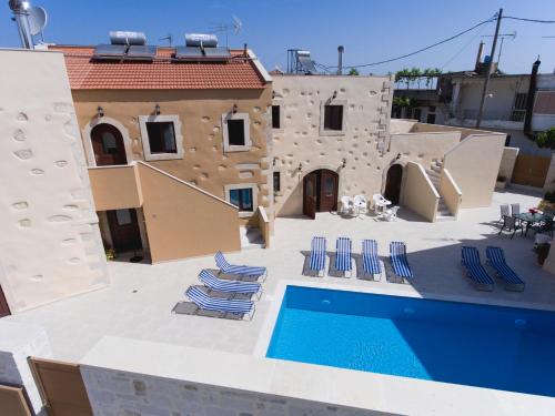 a patio with lounge chairs and a swimming pool at Villa Cardia in Kiriánna