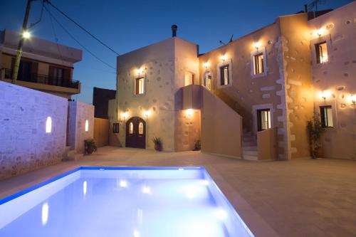 a swimming pool in front of a house at night at Villa Cardia in Kiriánna