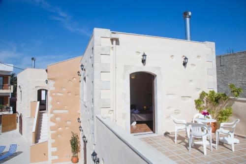 a white building with a table and chairs on a patio at Villa Cardia in Kiriánna