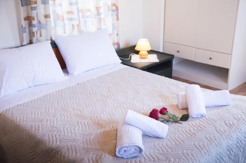 a bedroom with a bed with towels and flowers on it at Villa Cardia in Kiriánna