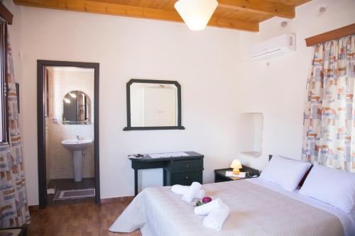 a bedroom with a bed and a sink and a mirror at Villa Cardia in Kiriánna