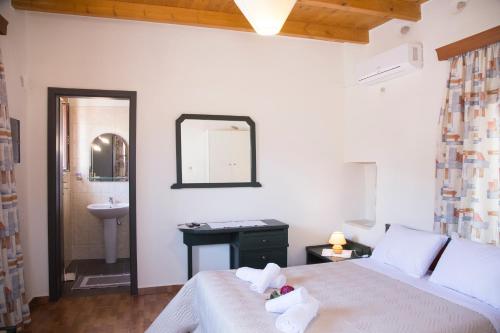 a bedroom with a bed and a sink and a mirror at Villa Cardia in Kiriánna