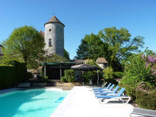 een zwembad met ligstoelen en een kasteel bij Chateau de Sadillac in Sadillac