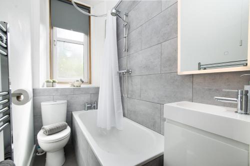 a white bathroom with a toilet and a sink at Beautiful, Traditional 2 Bedroom Main Door Flat in Edinburgh