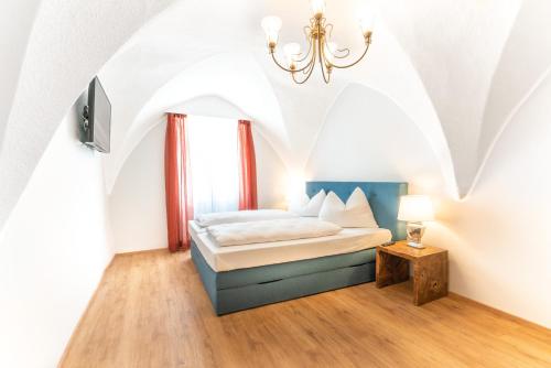 a bedroom with a bed and a chandelier at Altstadt Liebling in Vöcklabruck