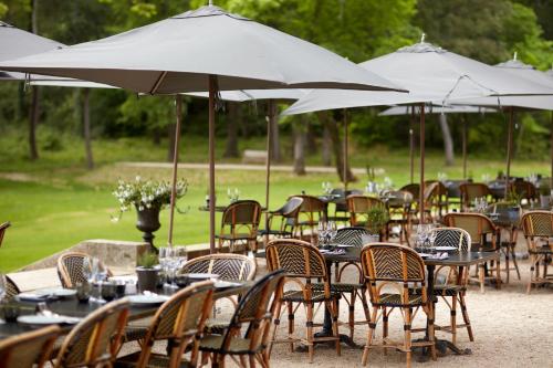 a group of tables and chairs with umbrellas at Domaine de Fontenille in Lauris