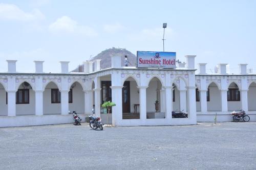 a white building with motorcycles parked in front of it at Hotel SunShine Palace in Chotila