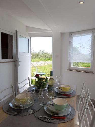 un tavolo da pranzo con piatti e bicchieri da vino di Apartment Ulika a Marčana