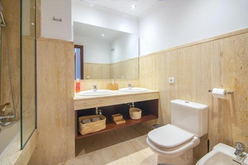 a bathroom with two sinks and a toilet and a mirror at Rooms & Suites Terrace 4D in Arrecife