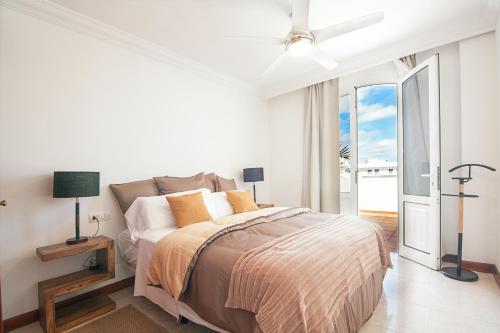 a white bedroom with a bed and a balcony at Rooms & Suites Terrace 4D in Arrecife