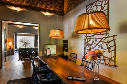 a dining room with a wooden table and two lights at Estancia La Paz Hotel in Ascochinga