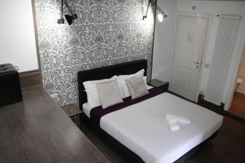 a bedroom with a white bedspread and white pillows at Relais Palazzo Taverna in Rome