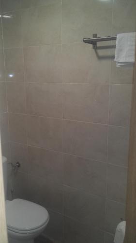a bathroom with a toilet and a tiled wall at Hospederia Gomis 26 in Ontinyent
