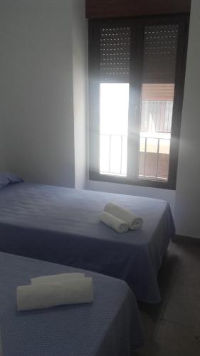 two beds in a room with two towels on them at Hospederia Gomis 26 in Ontinyent