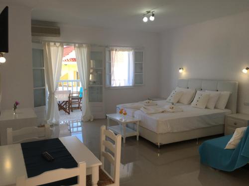 a bedroom with a bed and a living room with a table at Limnionas Bay Village Hotel in Marathokampos