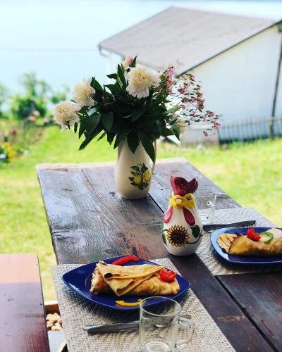 a table with plates of food and a vase with flowers at Dream Tricule in Sviniţa