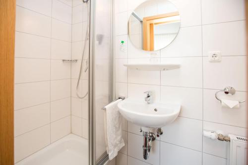 a white bathroom with a sink and a shower at Hotel Merle in Bruttig-Fankel