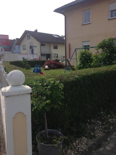 a white fence with a plant in a yard at Gästehaus Tante Tienchen 7 Minuten zu Fuss zum Europa Park , plus kostenloses Parkplatzticket Rulantica ,alle unsere Suiten haben einen Balkon in Rust