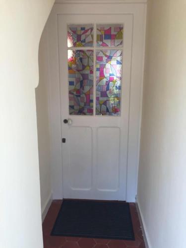 a hallway with a white door with a window at Le charme d'othe in Bellechaume