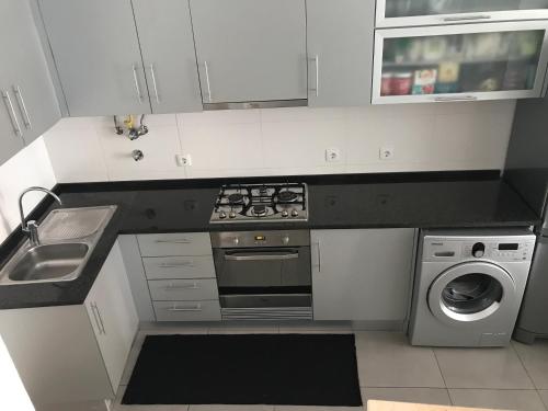 a kitchen with a stove top oven next to a dishwasher at Loft-Entre a praia e o campo in Nazaré