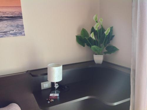 a room with a table with a lamp and a plant at BELLAVISTA B&b in Lamezia Terme