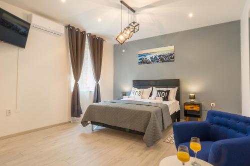um quarto com uma cama e um sofá azul em Rooms Sea & Sun with private parking em Zadar