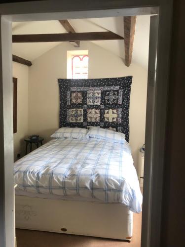 a bedroom with a bed with a black and white comforter at The Annexe Croughton in Banbury