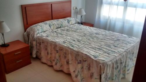 - une chambre avec un lit et une commode avec un couvre-lit dans l'établissement Apartamento en Águilas, à Águilas