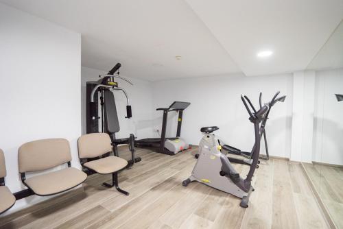 a gym with a treadmill and two exercise bikes at Hotel Pozo del Duque in Zahara de los Atunes