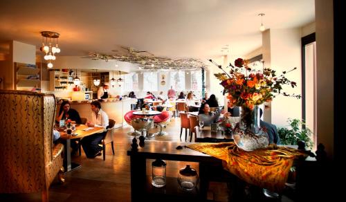 a group of people sitting at tables in a restaurant at Konak Hotel Taksim in Istanbul