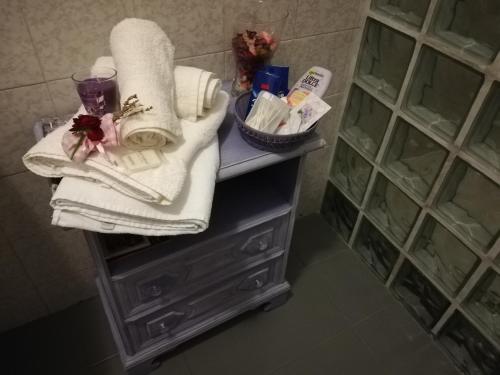 a bathroom counter with towels and a basket of toiletries at La Casa di Bacco B&B in Lerma