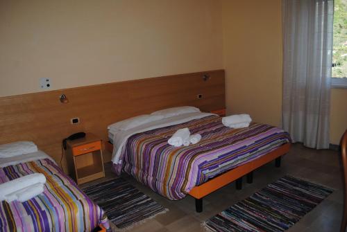 a bedroom with two beds with towels on them at Hotel South Paradise in Palmi