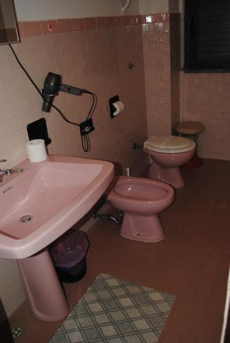a bathroom with a pink sink and two toilets at Hotel South Paradise in Palmi